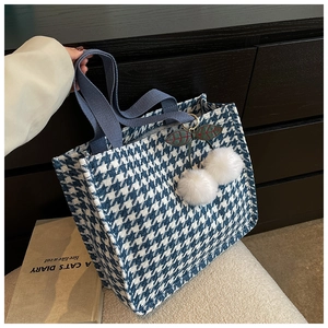 Detailed close-up of blue houndstooth tote bag featuring a cute cherry pompom charm