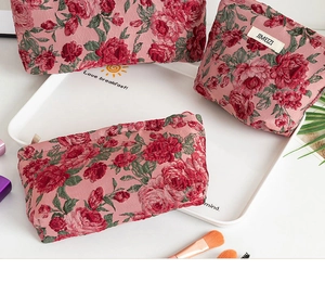 Set di tre borse da toilette con motivo jacquard a rose rosse e cerniere in metallo