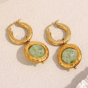 Macro view of 18K gold plated earrings with vintage green resin centerpieces