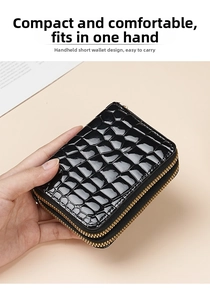 Close-up of black crocodile embossed patent leather wallet with double gold zippers