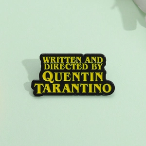 Quentin Tarantino enamel pin with yellow text on black background for bags and jackets