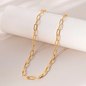Minimalist 18K gold plated safety pin chain necklace displayed on a white pedestal