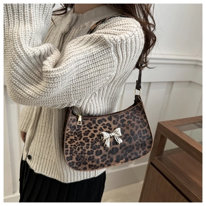 Detail of leopard print hobo bag with a silver butterfly buckle and gold zipper detail