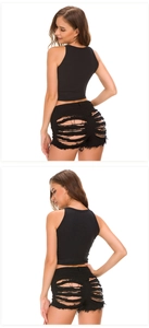 Detail view of black high waist denim shorts with heavy ripped design and frayed edges
