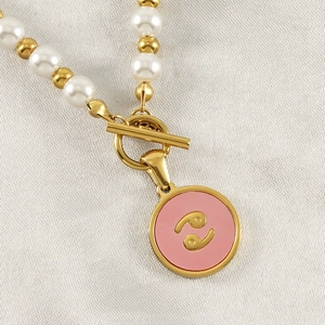 Detail of 18K gold-plated Pisces zodiac pendant with pearl chain and T-bar toggle clasp