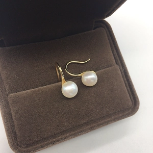 Detail of freshwater pearl earrings with gold hooks in a premium velvet display box