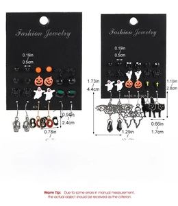 Detailed view of Halloween earring set with pumpkin and skull charms on display card