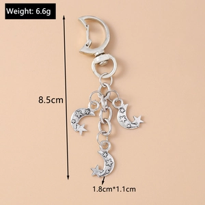 Detail shot of silver star and moon keychain with weight and size specifications