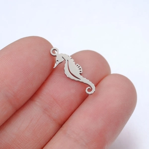 Macro shot showing the mini scale of a polished stainless steel seahorse pendant