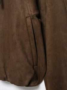 Detail of dark brown suede hooded bomber jacket showing pocket and fine stitching