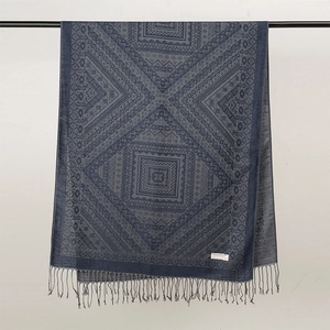 Dettaglio della sciarpa jacquard vintage blu scuro con motivi paisley e nappe decorative