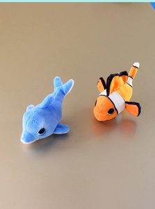 Detail of plush ocean animal fridge magnets featuring blue dolphin and orange clownfish