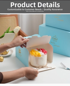 Detail showing hand opening light blue cake box with golden logo and fresh fruit cake