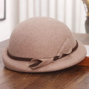 Detailed texture of wool beret featuring a contrast brown ribbon and elegant bow