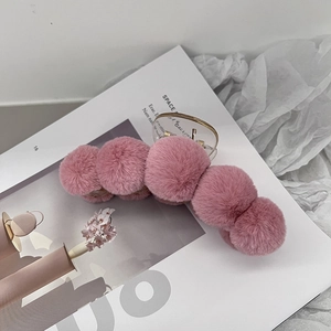 French style large pink plush claw clip hair accessory on a decorative magazine