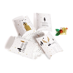 White Christmas pillow candy boxes with gold reindeer and polar bear designs on lace