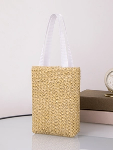 Detailed macro view of woven paper rope texture and wide white fabric handles on tote bag
