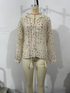 Detail of floral shirt featuring vertical lace cut-outs and white tassel drawstrings