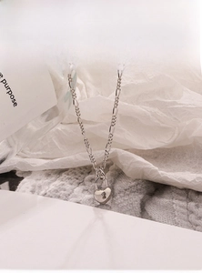 Detailed view of 925 sterling silver heart lock pendant with Figaro chain