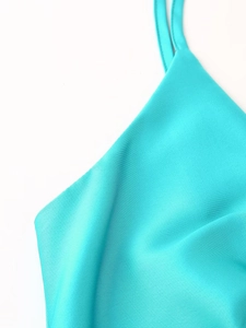 Gros plan sur le tissu en satin turquoise élégant avec une texture de soie lisse