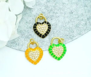 Close-up of enamel heart lock pendants in black, orange and green with 18K gold plating