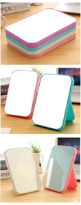Detail showing the foldable stand and four pastel colors of the rectangular makeup mirror
