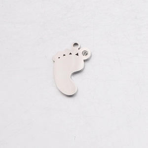 Macro shot of silver baby feet charm with rhinestone detail and round hanging loop