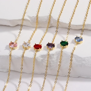 Gold-plated chain bracelet set with colorful oval zircon gemstones on textured background