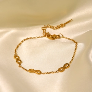 18K gold plated stainless steel bracelet with triple infinity symbols on white satin