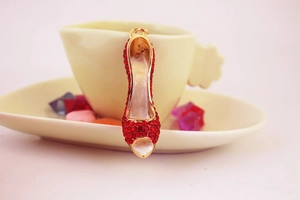 Sparkling red crystal high heel keychain hanging on a yellow ceramic cup for decoration