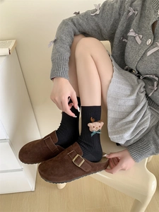 Detail of winter socks with 3D plush reindeer doll and brown suede clog sandals