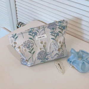 Floral canvas makeup bag with blue hydrangea print and gold embroidery details