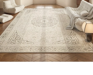 Detail of beige French vintage area rug with floral patterns on herringbone wood floor