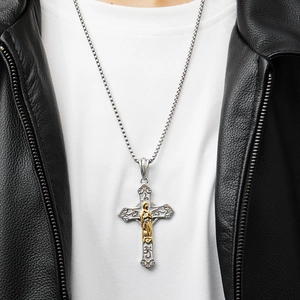 Macro view of silver cross pendant featuring a gold relief figure on a round bead chain
