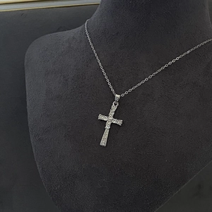 Collier croix argenté avec zircons blancs sur buste en velours noir pour exposition bijoux