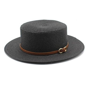 Détail d'un chapeau de paille noir avec ruban en cuir marron et boucle métallique