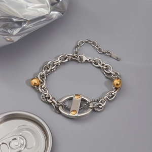 Vue macro d'un bracelet double rang en acier inoxydable avec billes dorées et fermoir