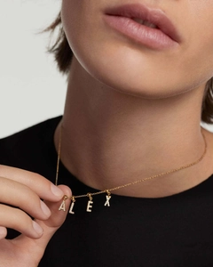 Detailed close-up of a personalized ALEX name necklace with pavé crystals on a gold chain