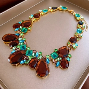 Dettaglio della collana dorata con cristalli colorati a goccia e base in metallo