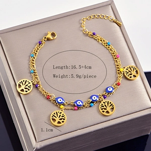 Detail of gold Tree of Life charm and blue Evil Eye on a double-layer chain bracelet