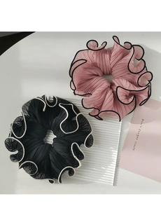 Detail of ruffled chiffon scrunchies in black and pink with contrasting edges