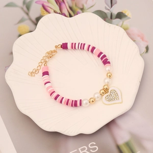 Colorful polymer clay heart bracelet with pearls and adjustable gold chain in shell tray