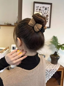 Brown plush bow hair claw clip styled on a high bun for autumn and winter fashion