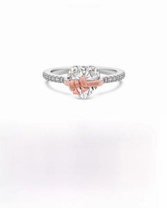 Macro detail of S925 silver ring featuring 8mm heart zircon and rose gold bow decoration