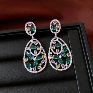 Detail of vintage hollow oval drop earrings with multi-colored cubic zirconia stones