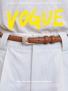 Gros plan d'une ceinture fine en cuir marron avec boucle dorée mate sur pantalon blanc
