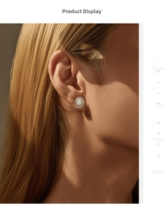 Close-up of elegant S925 silver oval opal stud earrings worn by a model in warm light