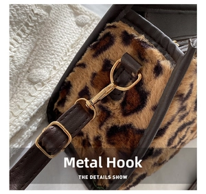 Detail of leopard print faux fur bag with gold hardware hooks and brown leather strap