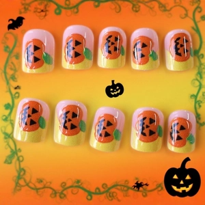 Halloween press-on nails with orange pumpkin faces in medium long French square style