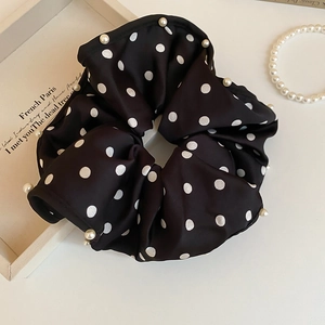 Detailed view of black polka dot satin scrunchie with elegant pearl edge embroidery